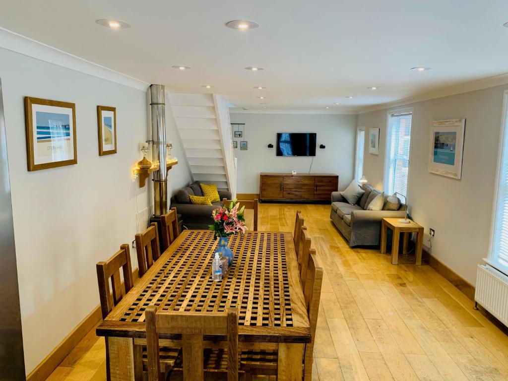 a living room with a table and a couch at Shepherds House in Swanage