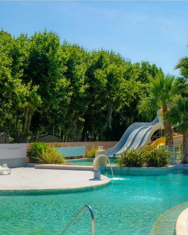 a slide in a swimming pool with a water park at Camping Parc des 7 fonts in Agde