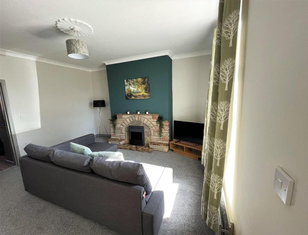 a living room with a couch and a fireplace at Luke Stays - Alum Waters in New Brancepeth