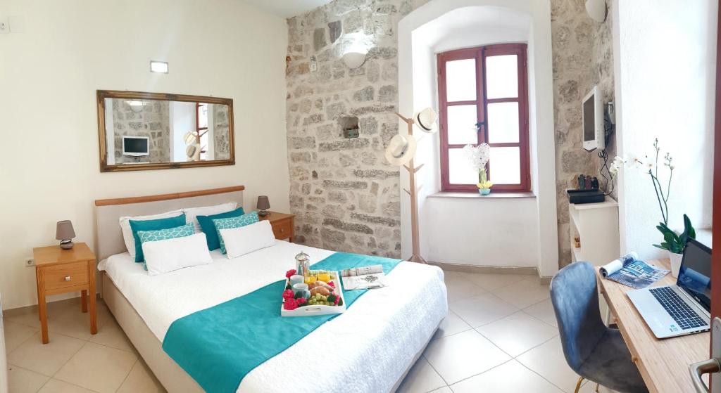 een slaapkamer met een bed en een dienblad met fruit erop bij La Dolce Vita Apartments in Kotor