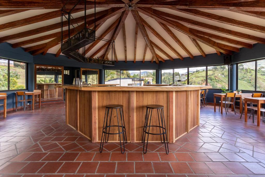a bar in a restaurant with chairs and tables at Soy Local Guatape in Guatapé