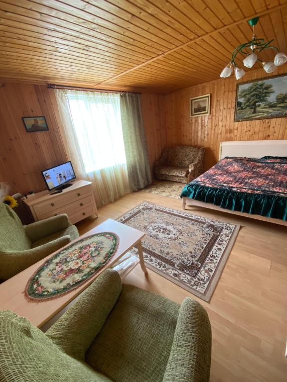 レスノイにあるHoliday Home On Zelenayaのリビングルーム(ベッド1台、ソファ、椅子付)