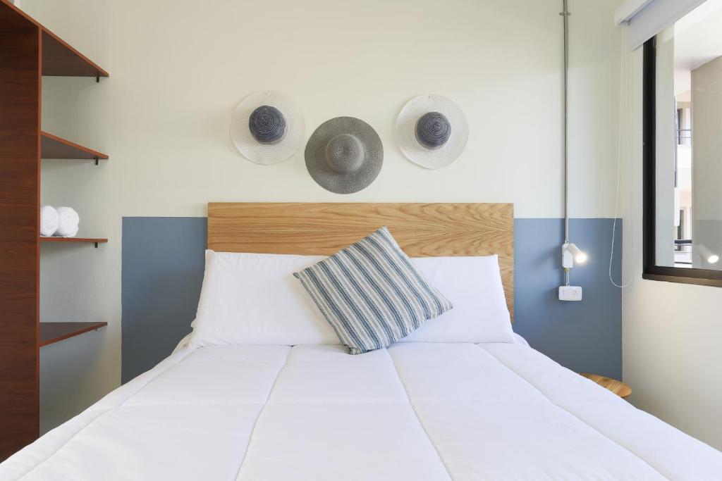 a bedroom with a white bed with two speakers on the wall at Soy Local Guatape in Guatapé