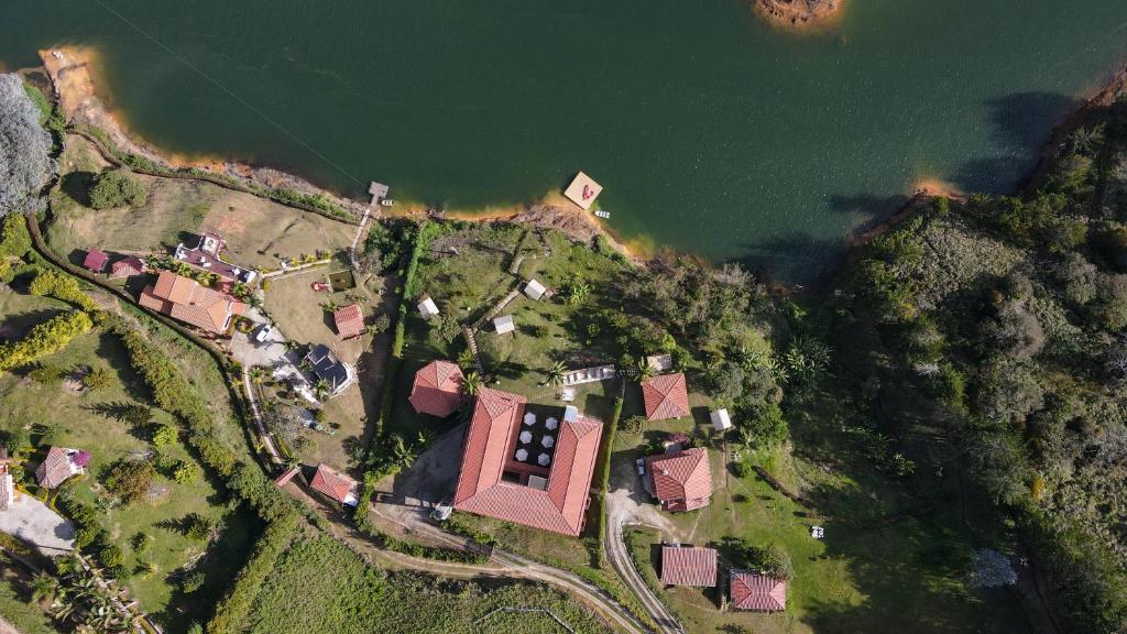 an aerial view of a house on a hill next to the water at Soy Local Guatape in Guatapé