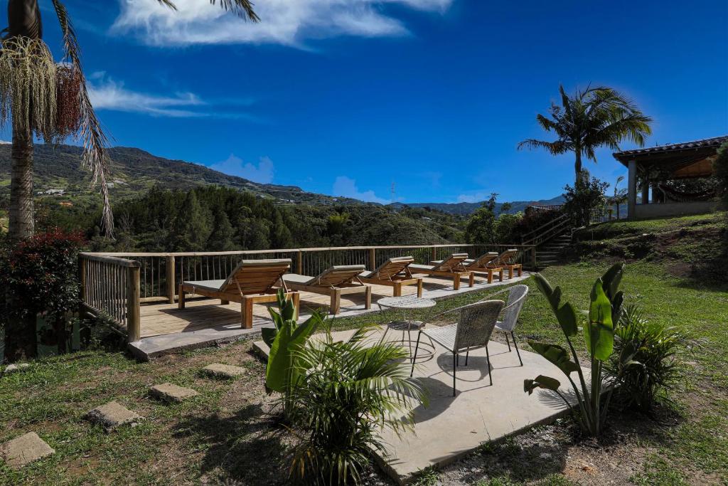 a group of chairs and tables on a deck with a mountain at Soy Local Guatape in Guatapé