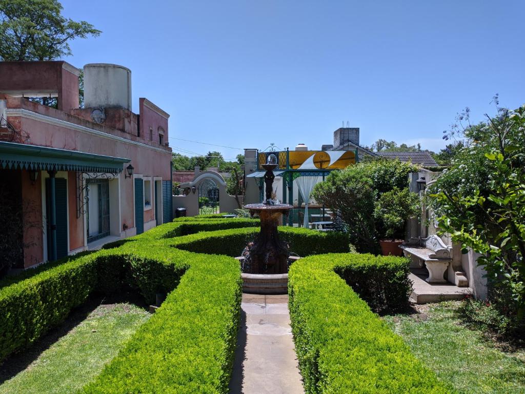 a fountain in the middle of a garden at Hotel Draghi in San Antonio de Areco