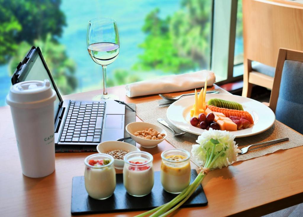 a table with a plate of food and a glass of wine at Catalonia Santo Domingo in Santo Domingo