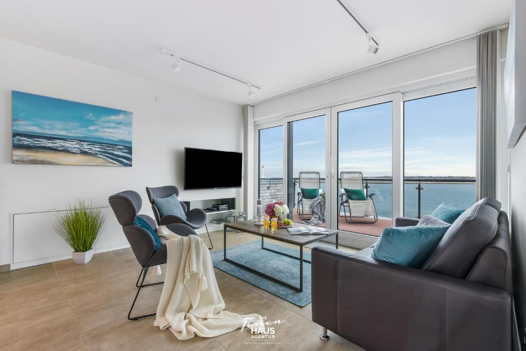 a living room with a view of the ocean at Dock 76 Bridge - Penthouse in Olpenitz