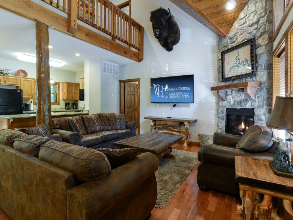 a living room with leather furniture and a stone fireplace at Lodge 243 in Branson