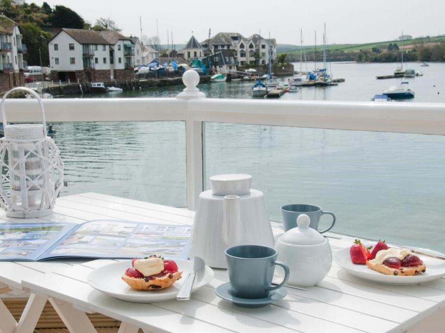 uma mesa com dois pratos de comida e chávenas de café em The Boathouse em Kingsbridge