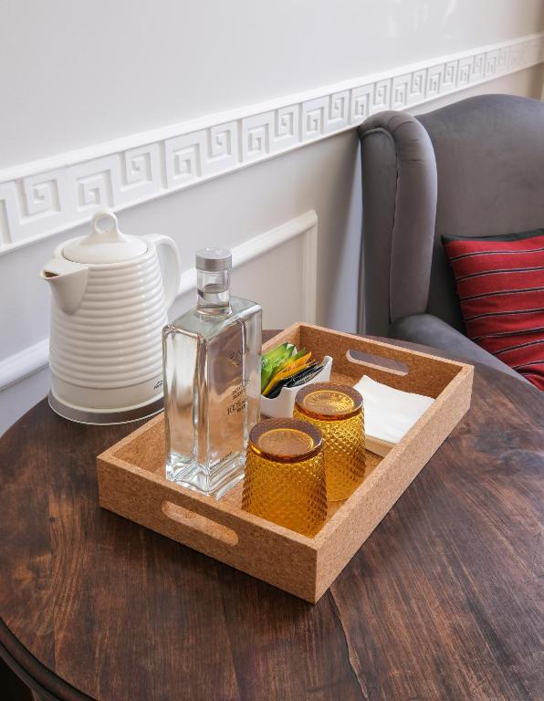 a glass bottle on a wooden tray on a table at 1869 Príncipe Real House in Lisbon