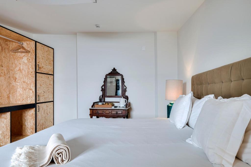 a bedroom with a large white bed with white pillows at 1869 Príncipe Real House in Lisbon