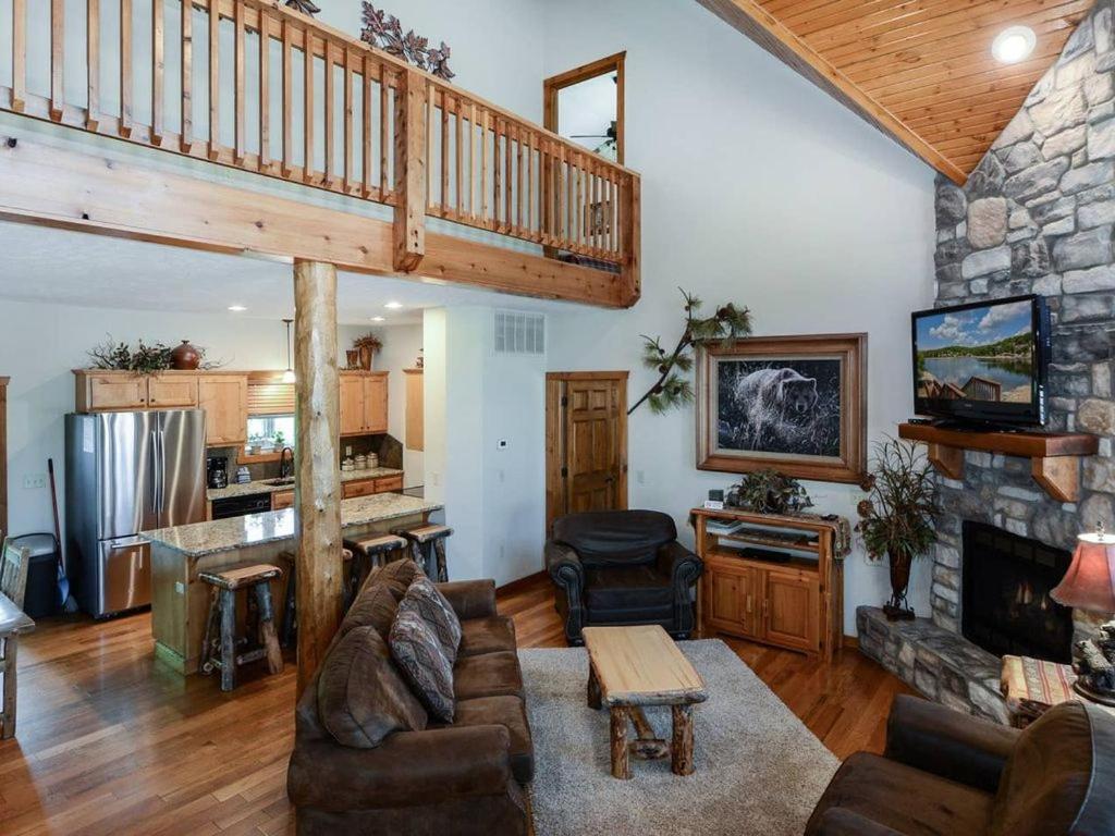 uma sala de estar com uma escada e uma lareira de pedra em Lodge 371 em Branson