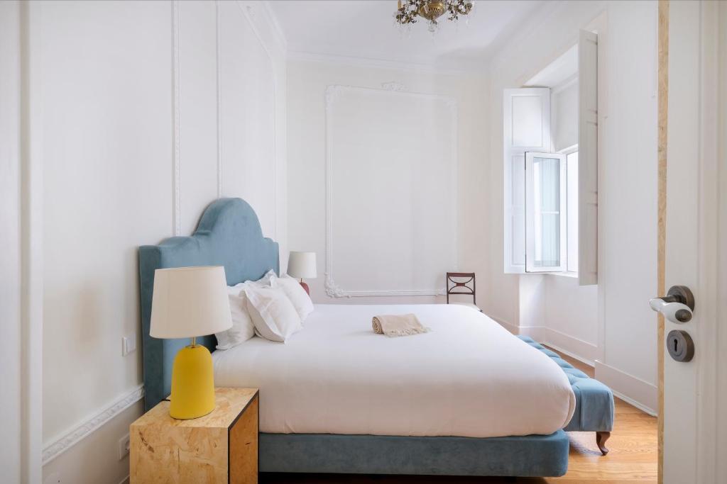a bedroom with a bed with a blue headboard at 1869 Príncipe Real House in Lisbon