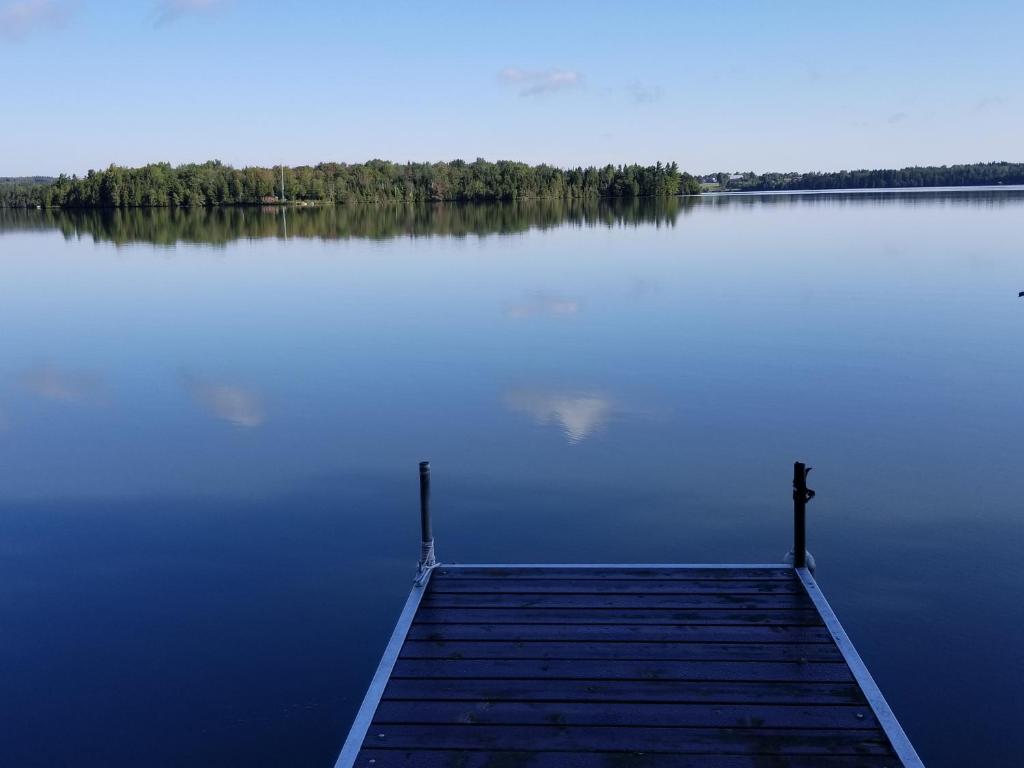 a dock in the middle of a large lake at La Parade du Huard - Lac et Spa in Saint Sebastien