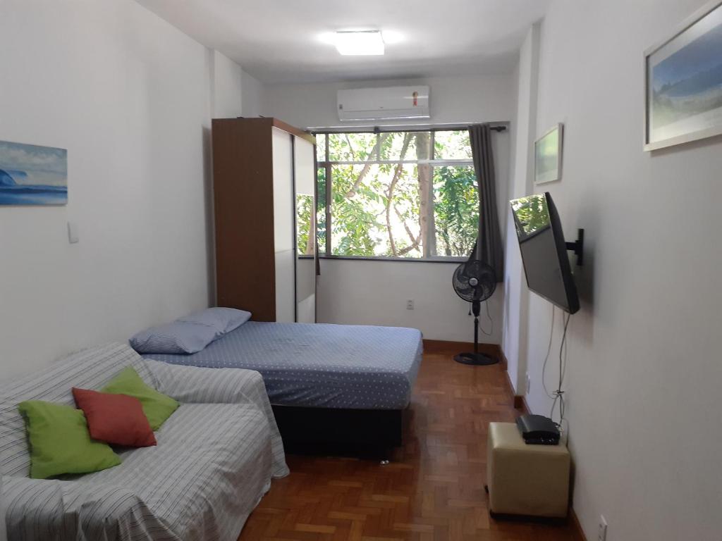 um quarto com 2 camas, uma televisão e uma janela em Ipanema Paz e Amor no Rio de Janeiro