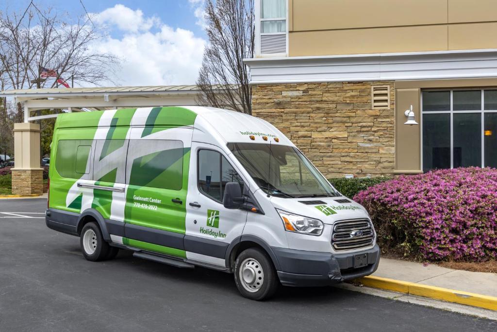 a green and white van parked in front of a building at Holiday Inn Atlanta-Gas South Arena Area, an IHG Hotel in Duluth