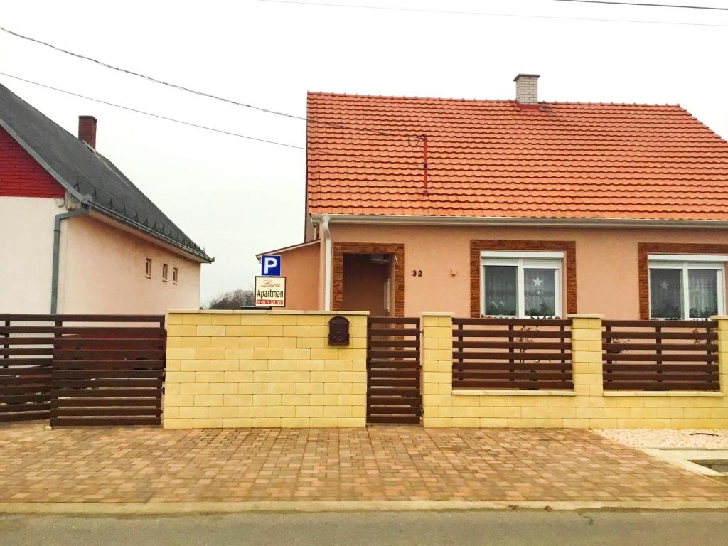 una casa con una valla amarilla delante de ella en Lara Apartman, en Kisvárda