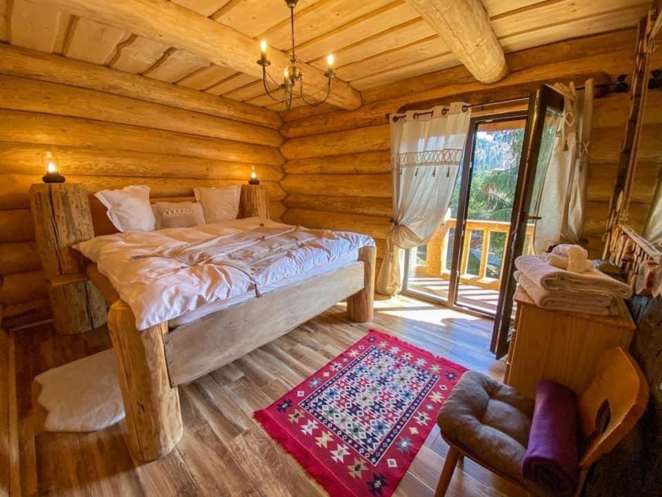 ein Schlafzimmer mit einem Bett in einer Blockhütte in der Unterkunft The Mountain's Sea Chalet in Colibiţa