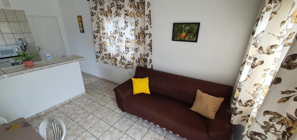 a living room with a brown couch with yellow pillows at Boa Vista Inn Guest House in Boa Vista