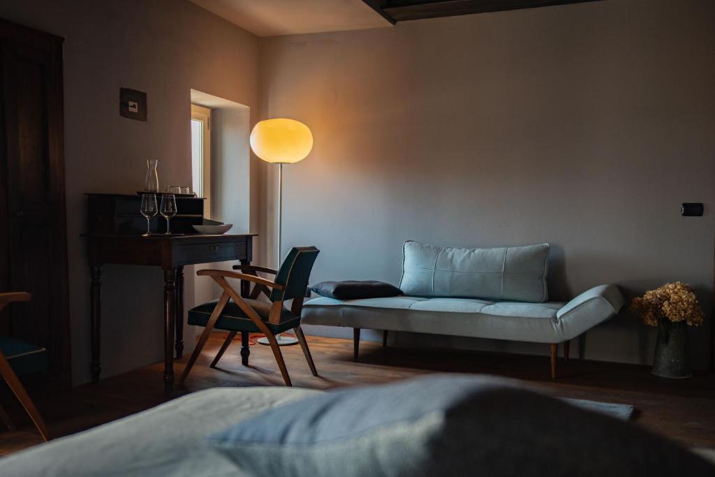 ein Wohnzimmer mit einem Sofa und einem Stuhl in der Unterkunft Boutique Hotel Al Palazzo Rosso in Neive