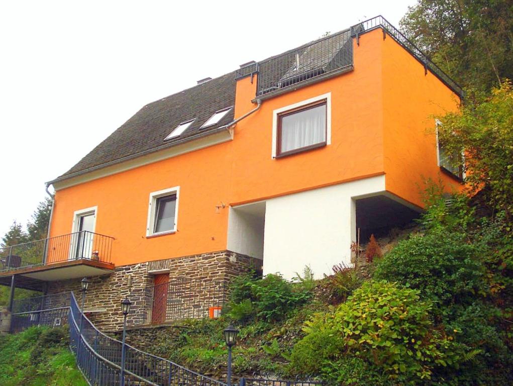 een oranje en wit huis op een heuvel bij Ferienwohnung Rheinblick Bacharach am Rhein in Bacharach
