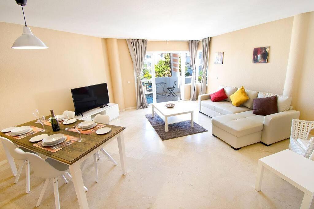 a living room with a table and a couch at Spectacular Apartment in Matchroom Country Club in Fuengirola