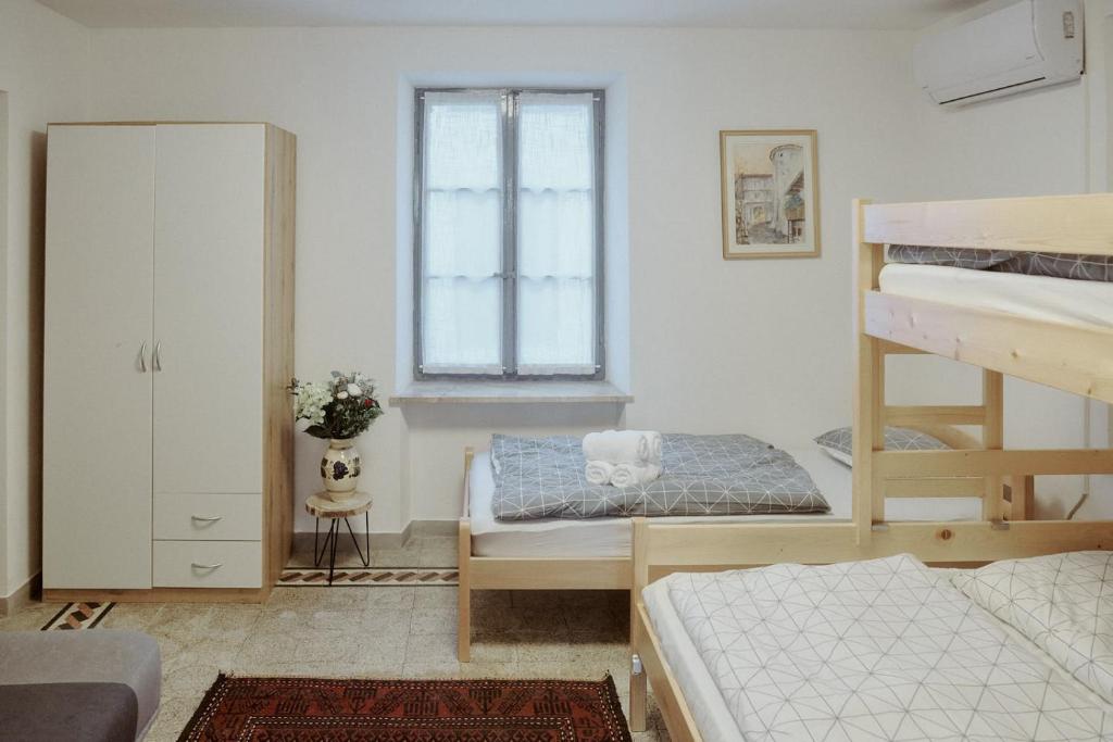 een slaapkamer met 2 stapelbedden en een raam bij Apartments Pr' Štormanu in Kanal