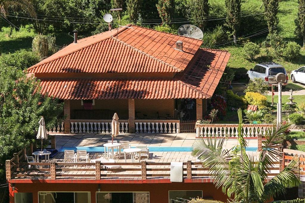 une maison avec un toit orange et une piscine dans l'établissement Chales em Salesopolis - Recanto da Barra, à Salesópolis