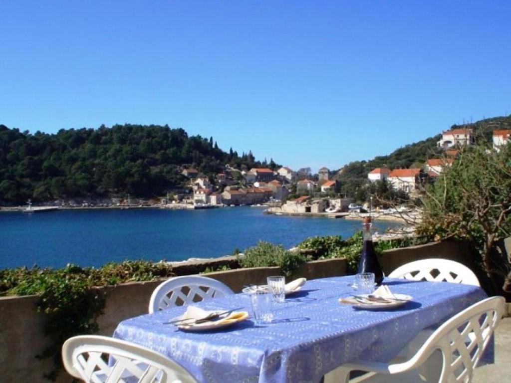 une table bleue avec des chaises et une vue sur le lac dans l'établissement Guest House Simunovic, à Suđurađ