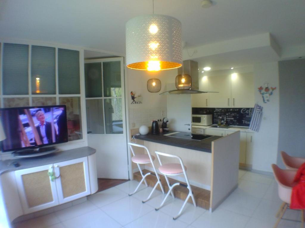 a kitchen with a island with chairs and a tv at Liège centre 6 rue montagne sainte Walburge, 4000 Liège, à 3 minutes de la gare st Lambert in Liège