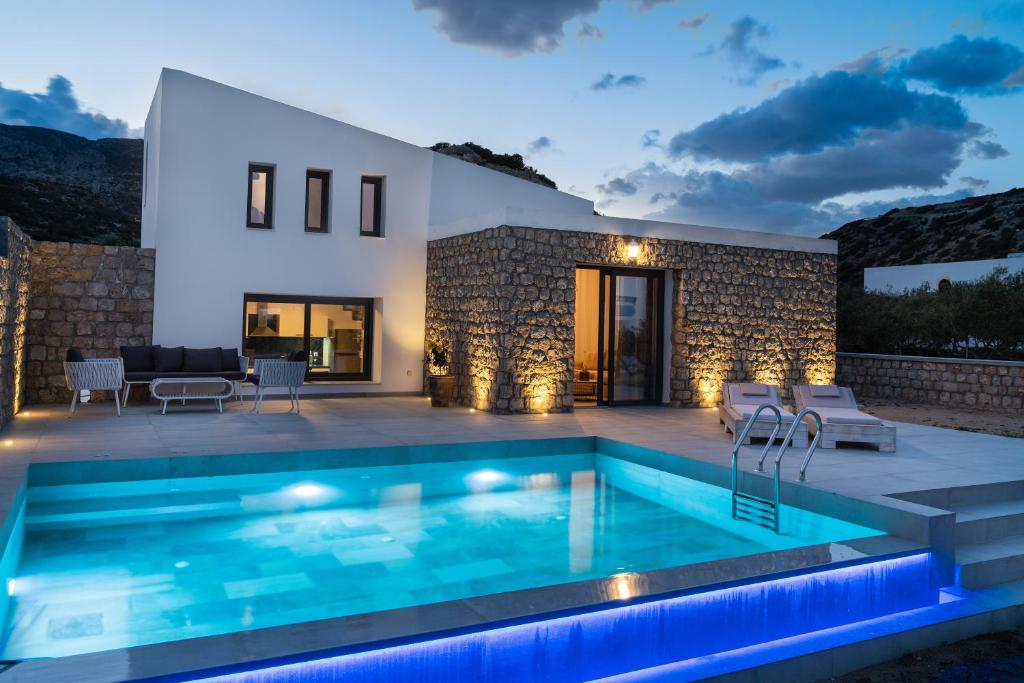 Villa con piscina por la noche en Askelinos Villas en Kárpatos