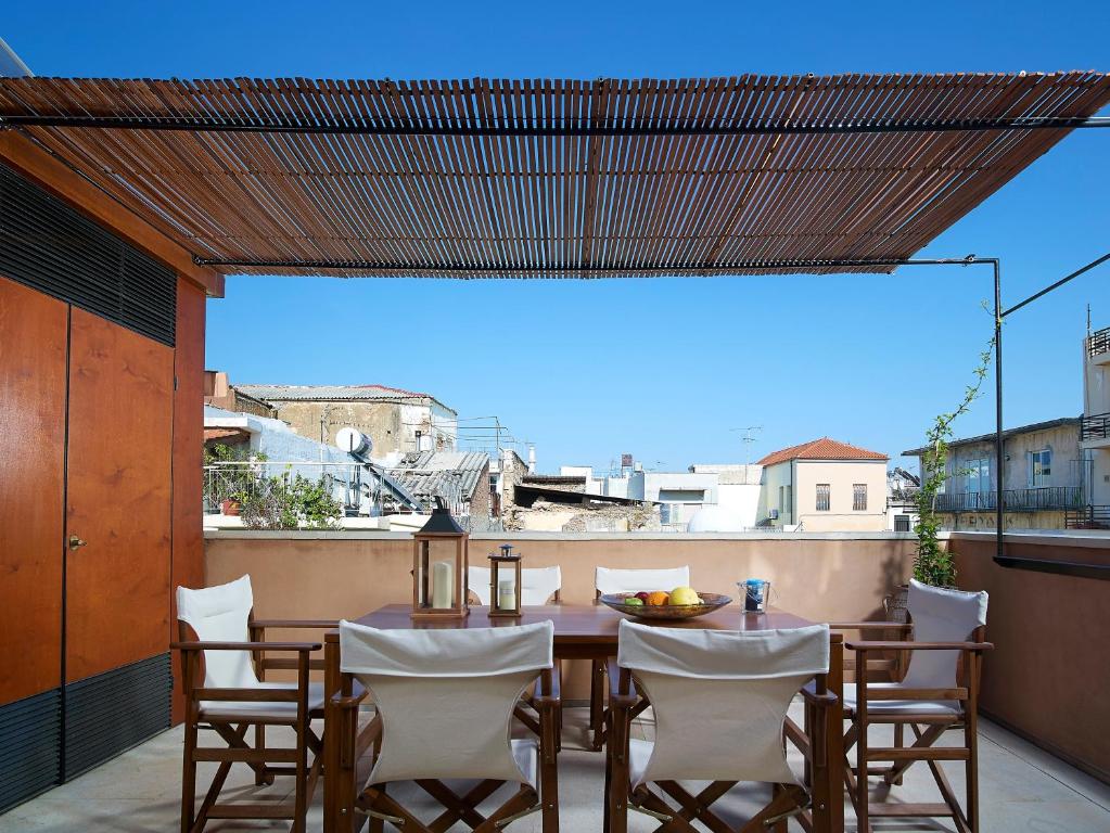 a patio with a table and chairs on a balcony at Dorotheou House in Chania