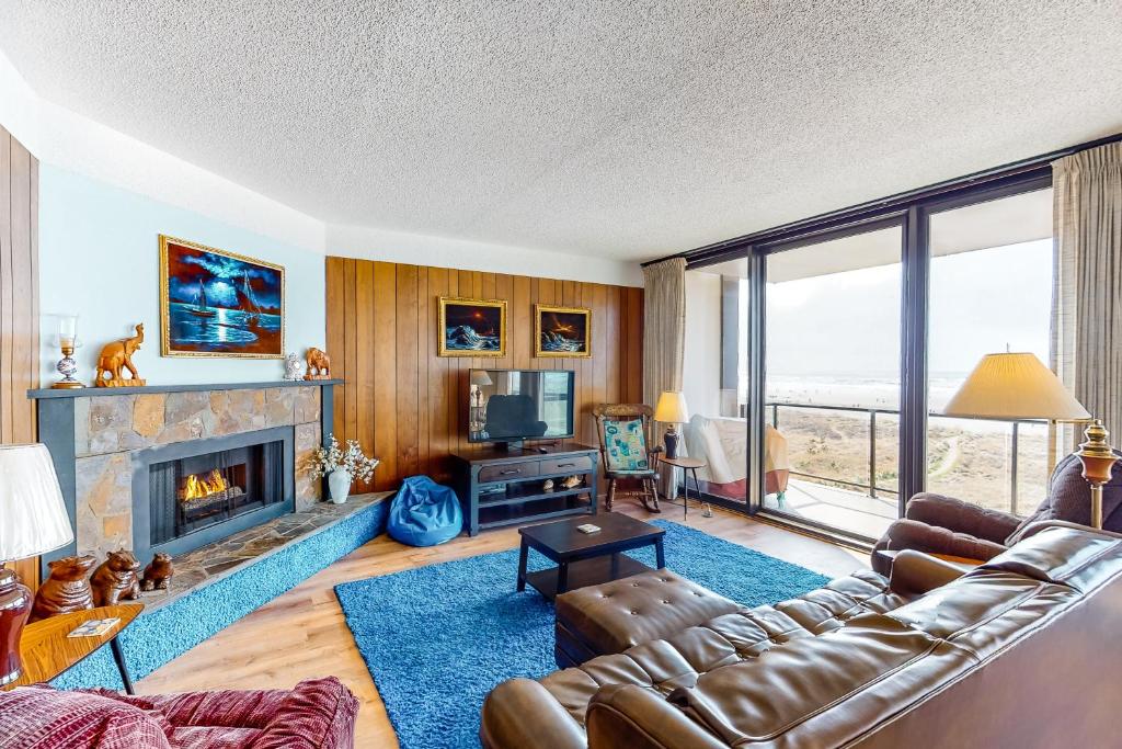 a living room with a couch and a fireplace at Sand and Sea #304 in Seaside