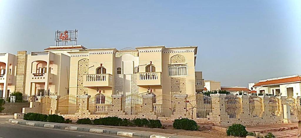 duży budynek z płotem przed nim w obiekcie Classic House Dahab w mieście Dahab
