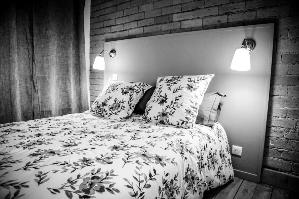 a black and white bedroom with a bed and two pillows at Duplex centre ville in Saint-Flour