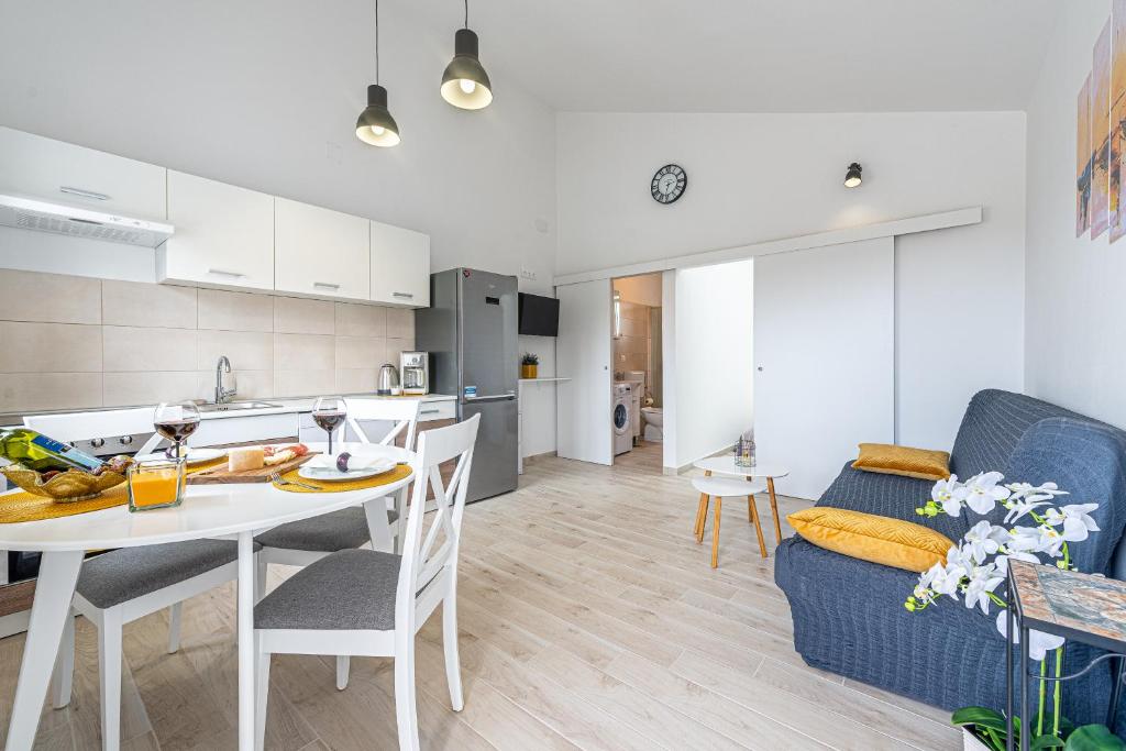 a kitchen and living room with a table and a couch at Apartmani Opg Dragoslavić in Stara Vas