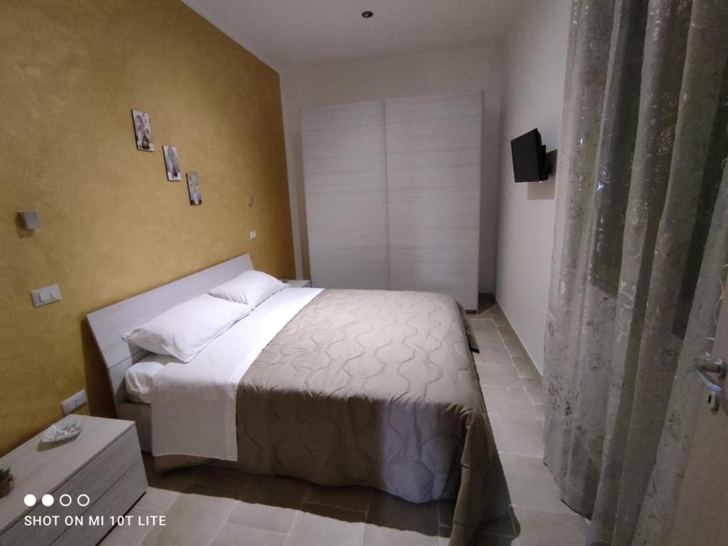 1 dormitorio con cama blanca y ventana en La Chianca en Leverano