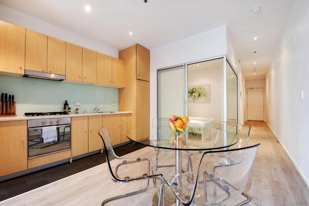 a kitchen with a glass table with a vase of flowers on it at Swainson on Bent in Adelaide