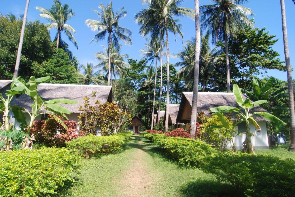 un chemin en face d'un complexe avec des palmiers dans l'établissement Lanta Coral Beach Resort, à Ko Lanta