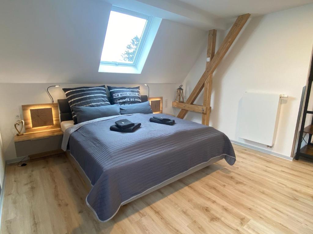 Schlafzimmer mit einem Bett mit blauer Bettwäsche und einem Fenster in der Unterkunft my inn in Chemnitz