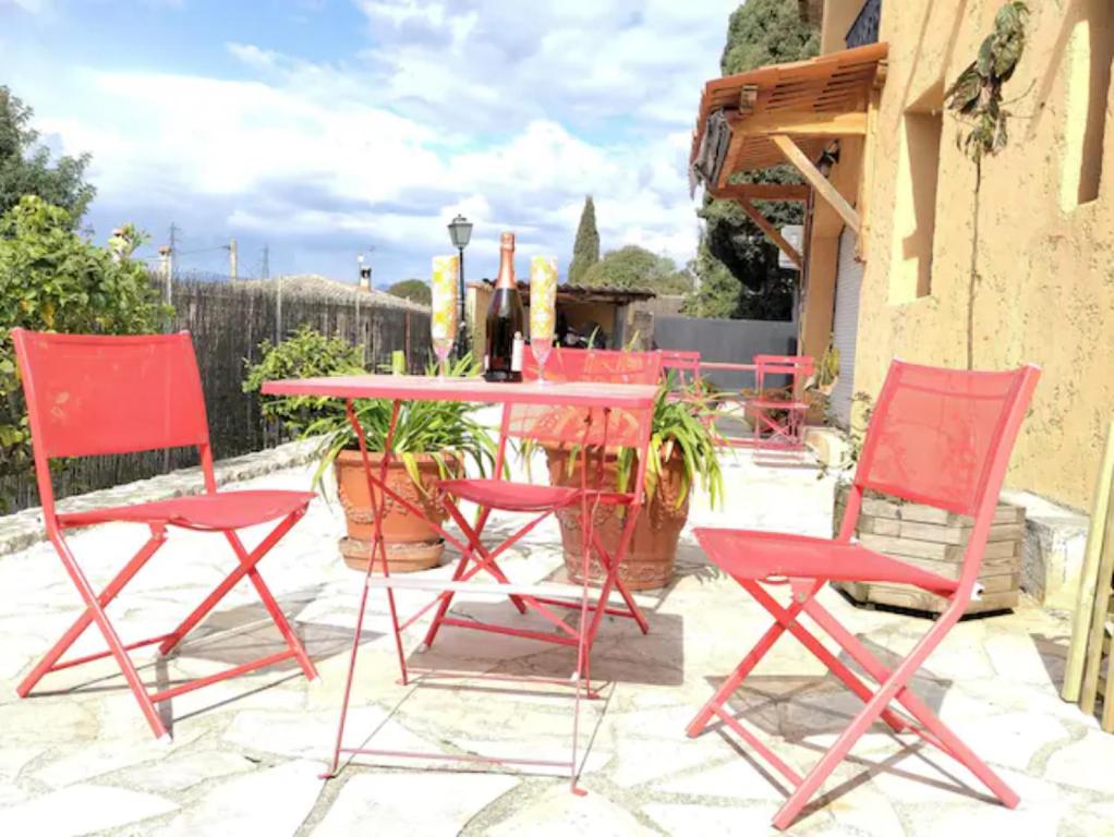 - une table et des chaises rouges sur la terrasse dans l'établissement Idéal pied à terre proche Cannes & Sophia, parking, à Mougins