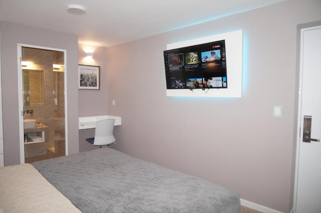 a bedroom with a bed and a television on the wall at Hotel Don Bartolo in Espinar