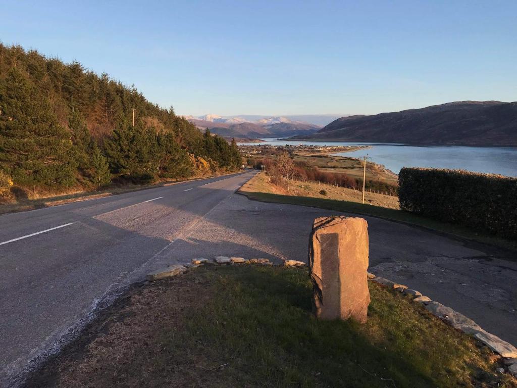 an empty road next to a body of water at Croft No.8 Bed & Breakfast in Ullapool