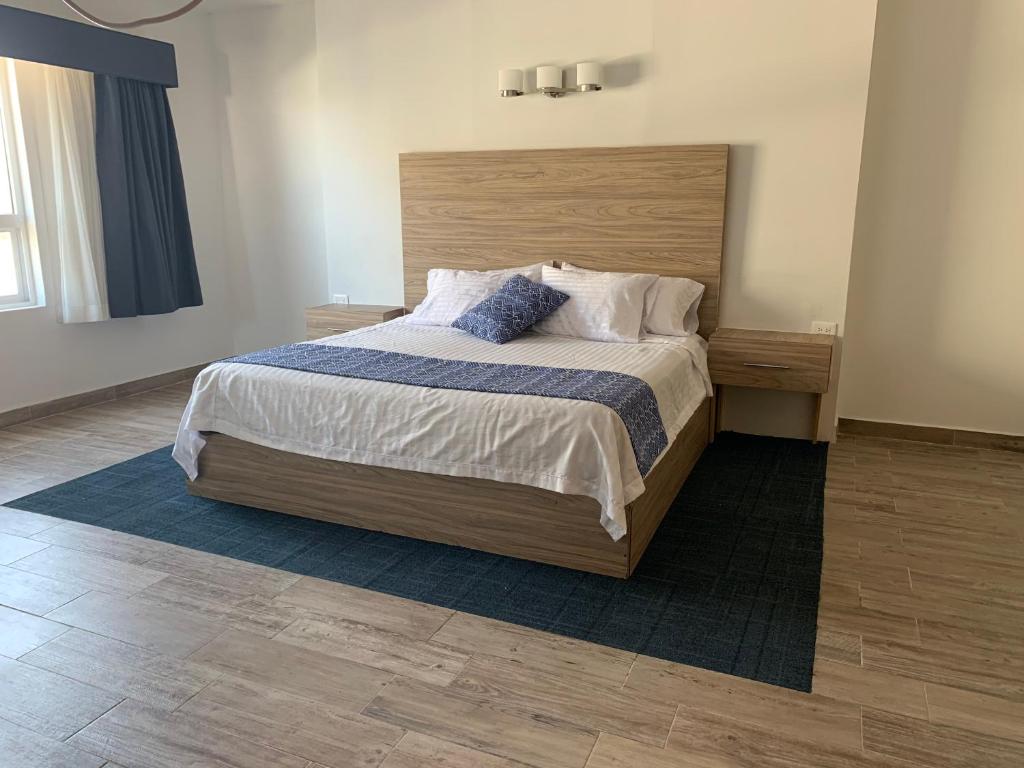 sypialnia z dużym łóżkiem z drewnianym zagłówkiem w obiekcie Hotel Flamingo w mieście Ciudad Juárez