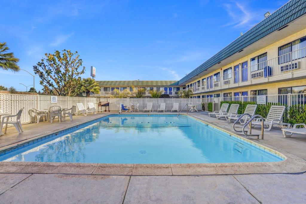 a swimming pool with chairs and a building at Motel 6-King City, CA in King City