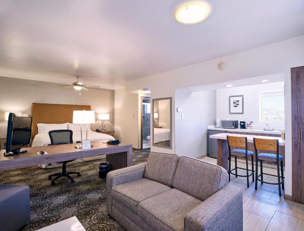 uma sala de estar com um sofá e uma cama e uma cozinha em Holiday Inn Hotel & Suites Chihuahua, an IHG Hotel em Chihuahua