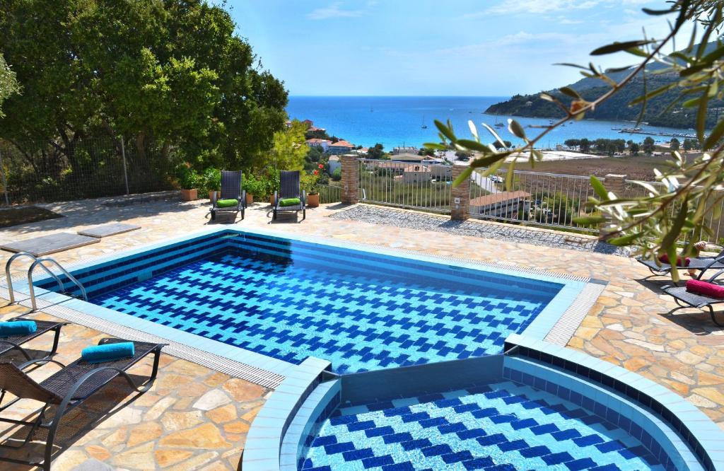 a swimming pool with chairs and the ocean in the background at Villa Tireda in Keri