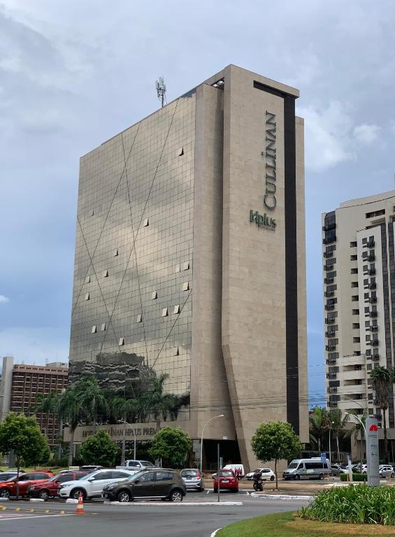 a large building with cars parked in front of it at Localização incrível vista ótima equipado e novo in Brasília