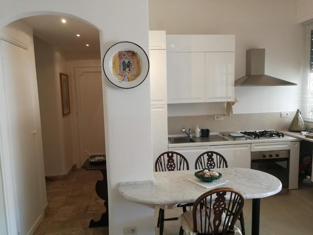 een keuken met een tafel en een klok aan een muur bij Intero Appartamento a soli 50 m dal mare in Viareggio